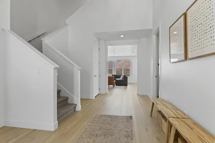 Foyer with stairs, light wood finished floors, and recessed lighting