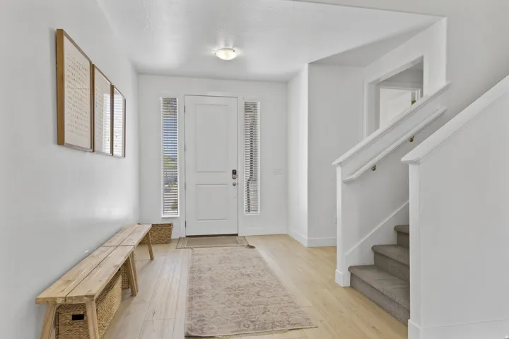 Entryway with light wood-style flooring and stairs