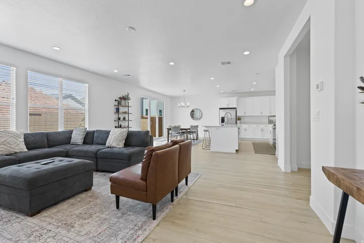 Living area with a chandelier, light wood finished floors, and recessed lighting