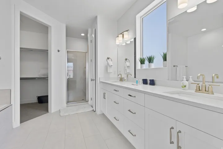 Full bathroom with double vanity, a shower stall, a spacious closet, recessed lighting, and light tile patterned flooring