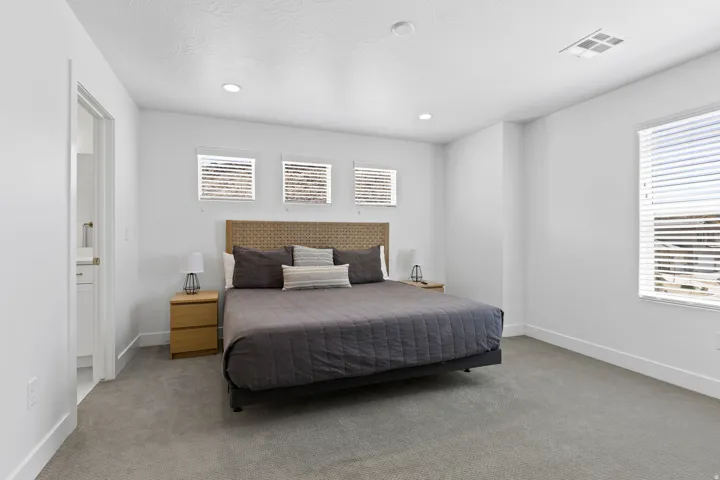 Carpeted bedroom featuring ensuite bathroom and recessed lighting