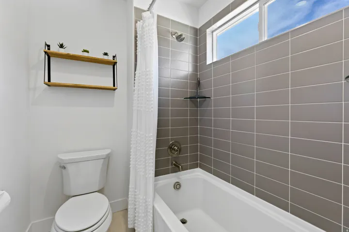Bathroom featuring shower / tub combo with curtain and toilet