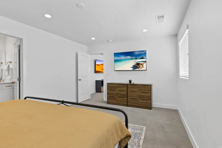 Bedroom with light colored carpet and recessed lighting