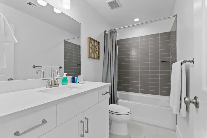 Bathroom with vanity, shower / bathtub combination with curtain, light tile patterned floors, and recessed lighting