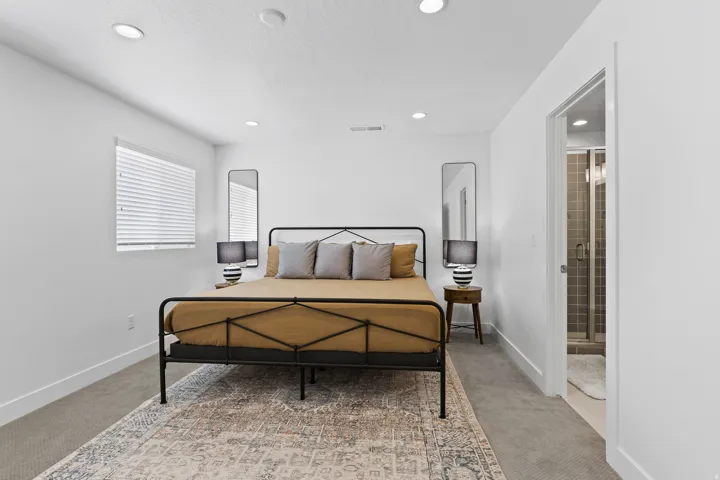 Bedroom with light carpet, recessed lighting, and ensuite bathroom