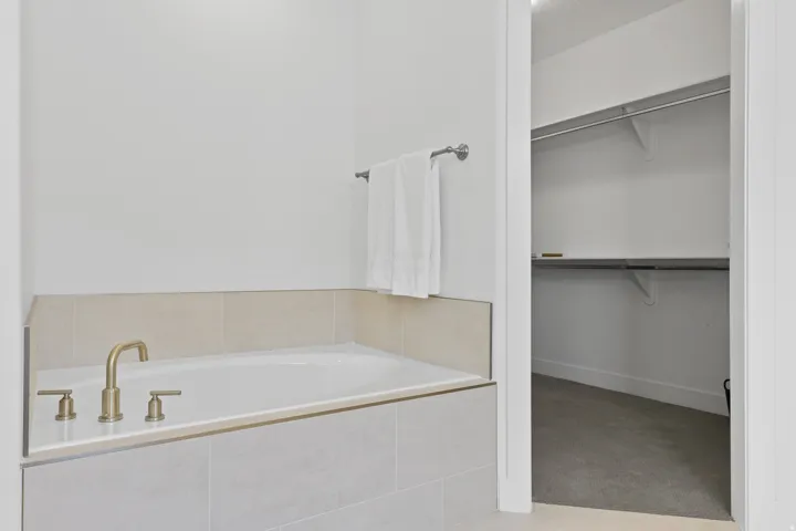 Full bathroom with a bath, a walk in closet, and carpet flooring