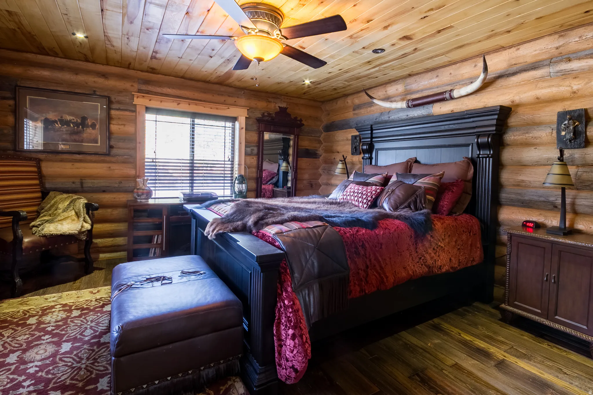 Bedroom featuring hardwood / wood-style flooring, wooden ceiling, a ceiling fan, and rustic walls