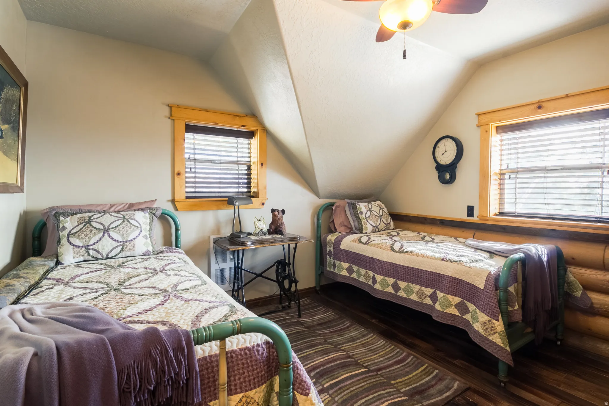 Bedroom featuring dark wood-style floors, lofted ceiling, a textured ceiling, ceiling fan, and multiple windows
