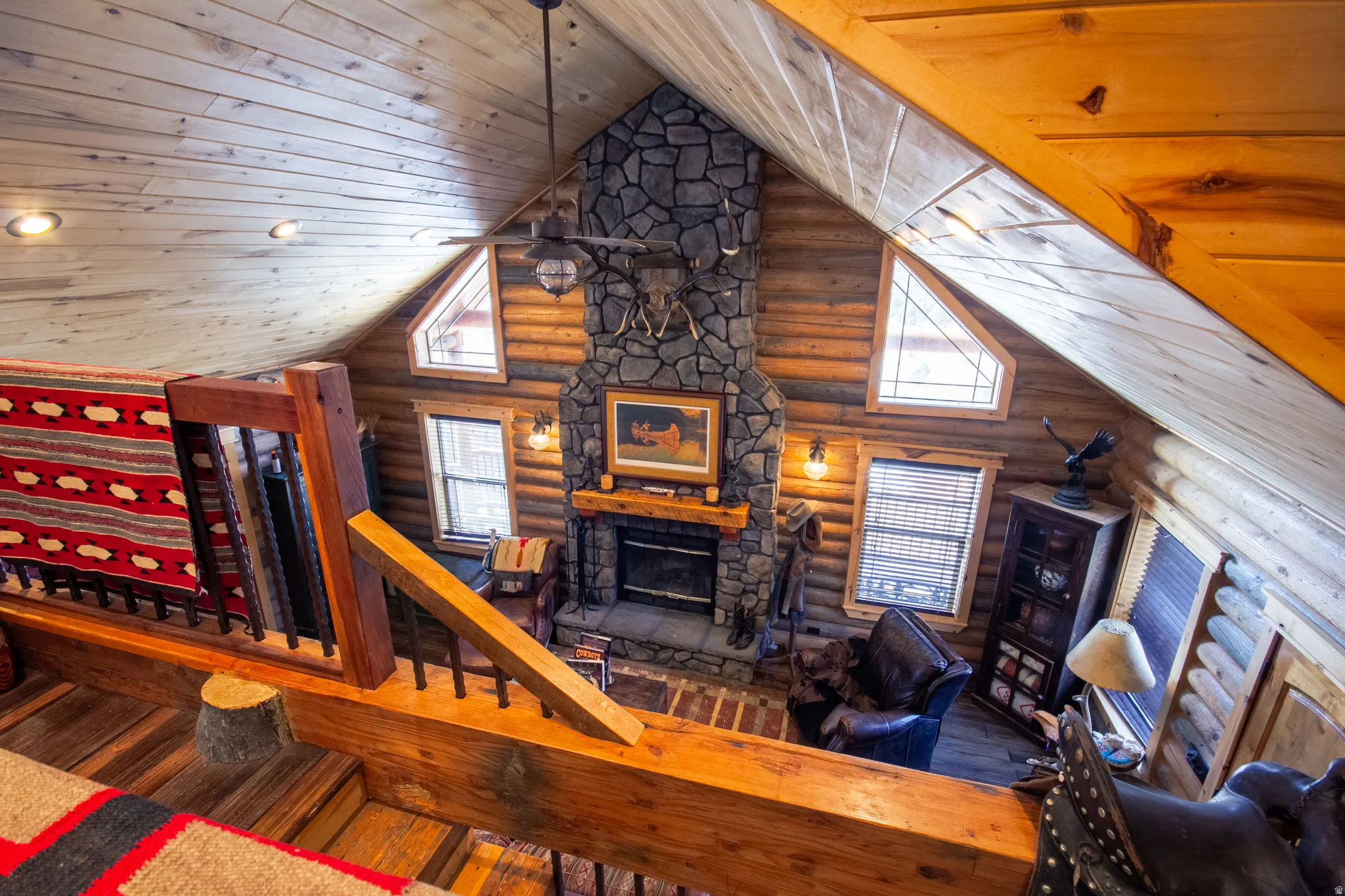 Living room featuring wood-type flooring, log walls, a fireplace, wood ceiling, and high vaulted ceiling