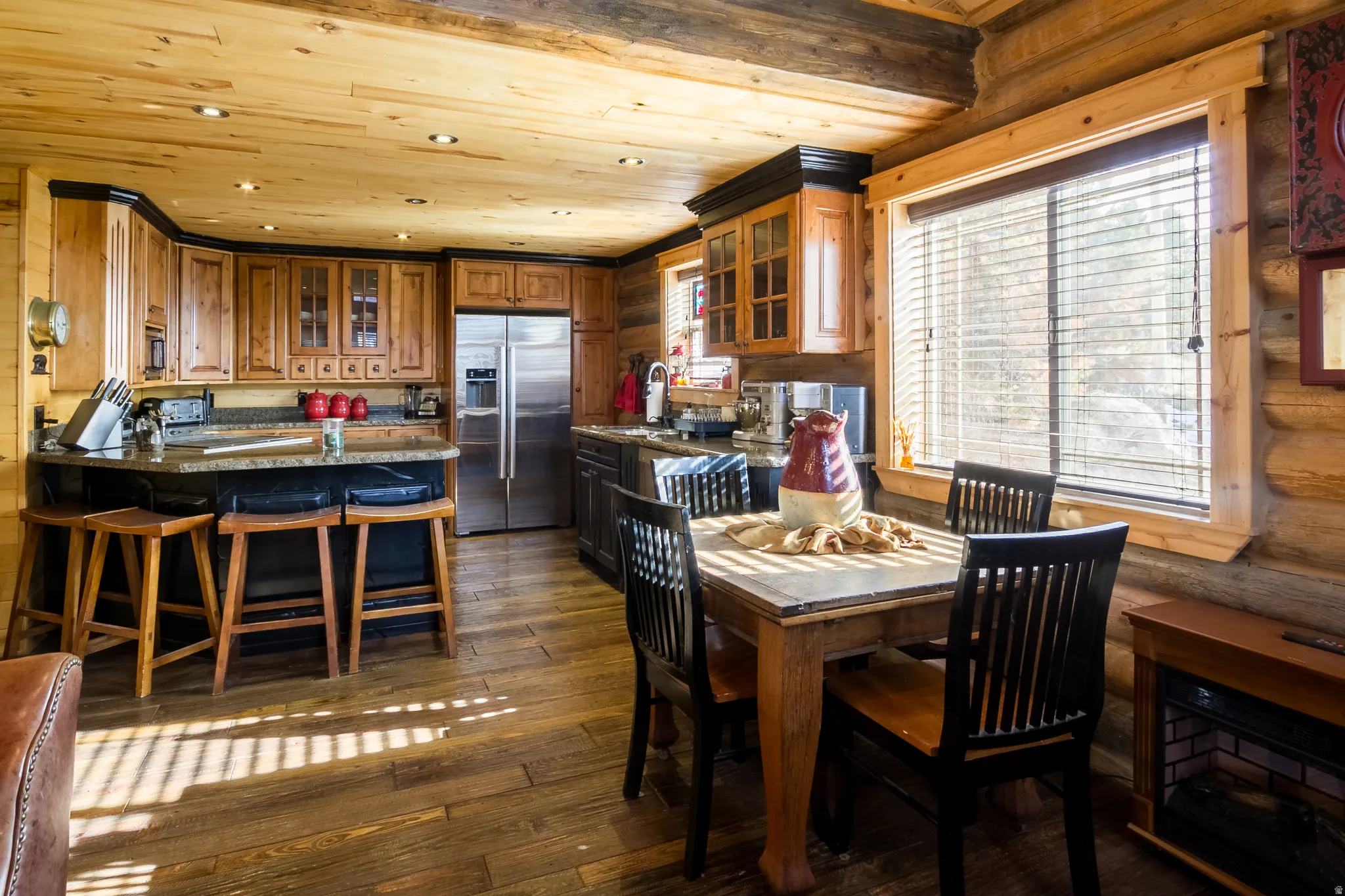 Dining space featuring dark wood-type flooring, recessed lighting, wood ceiling, and rustic walls