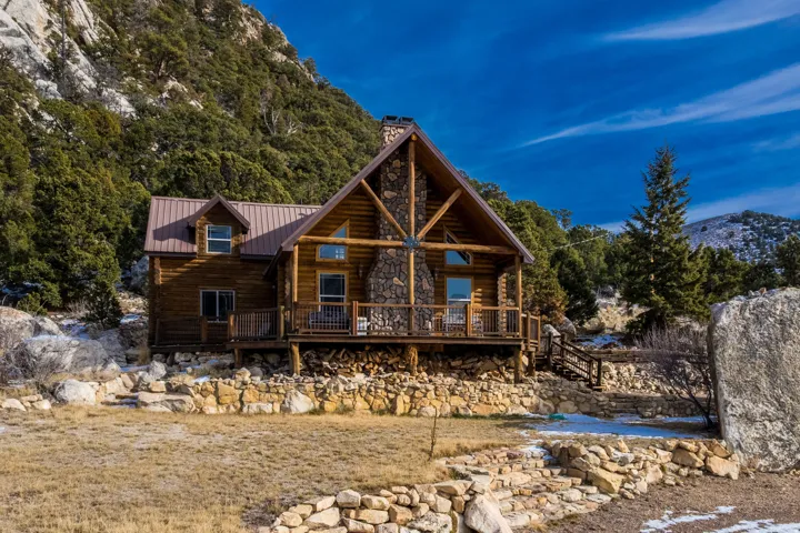 Back of house featuring a metal roof, a deck with mountain view, and a chimney