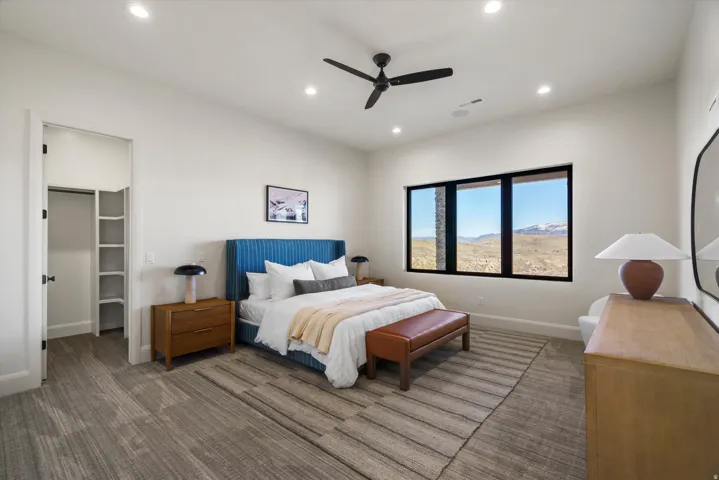 Bedroom with a spacious closet, recessed lighting, carpet flooring, a ceiling fan, and a mountain view