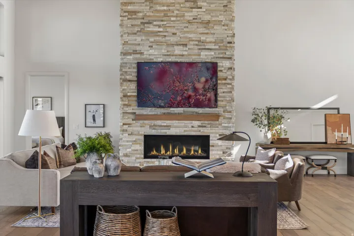 Living area with wood-type flooring, a fireplace, and a high ceiling