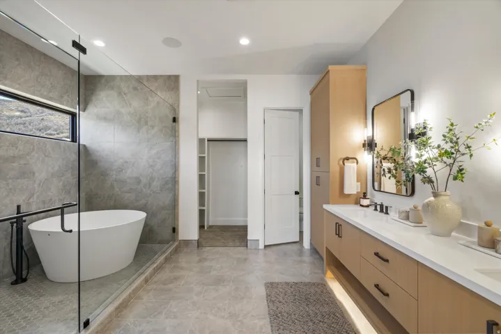 Full bathroom featuring double vanity, a soaking tub, a tile shower, tile walls, and recessed lighting