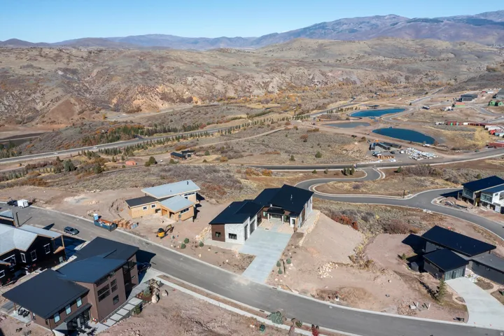 Aerial view of property and surrounding area with mountains and nearby suburban area