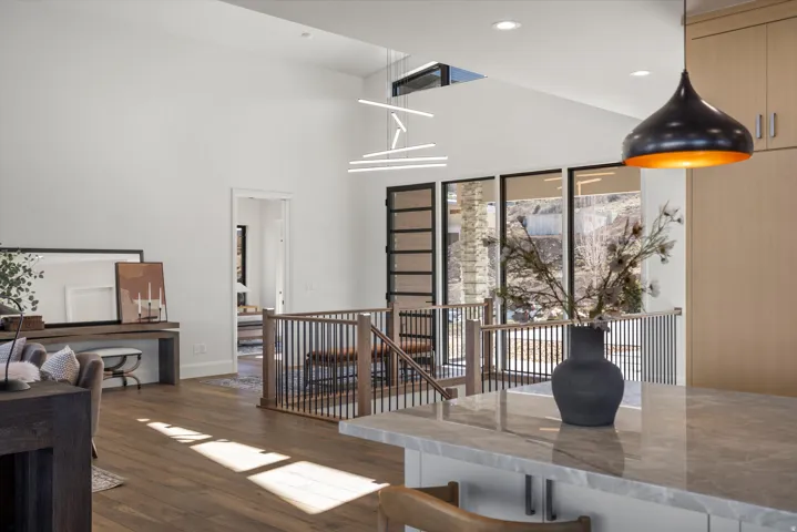 Interior space with dark wood-style floors, a high ceiling, and recessed lighting