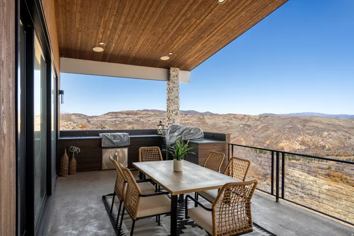 Balcony with a mountain view, outdoor dining area, and a grill