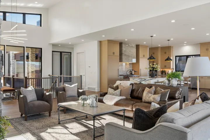 Living area with light wood finished floors, recessed lighting, and a high ceiling