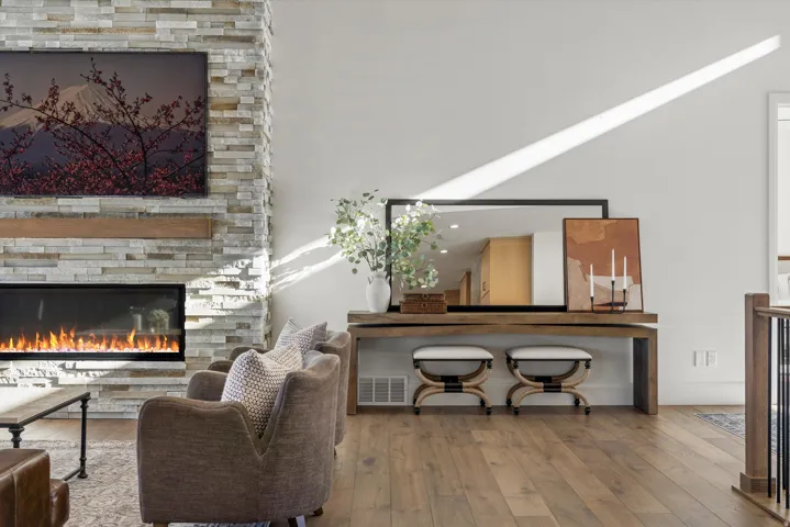 Living area with a stone fireplace and light wood finished floors