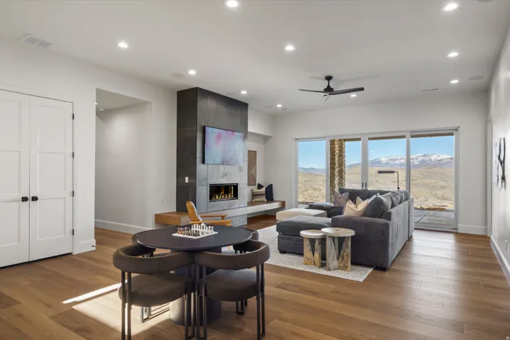 Living area featuring wood finished floors, a ceiling fan, a tile fireplace, and recessed lighting