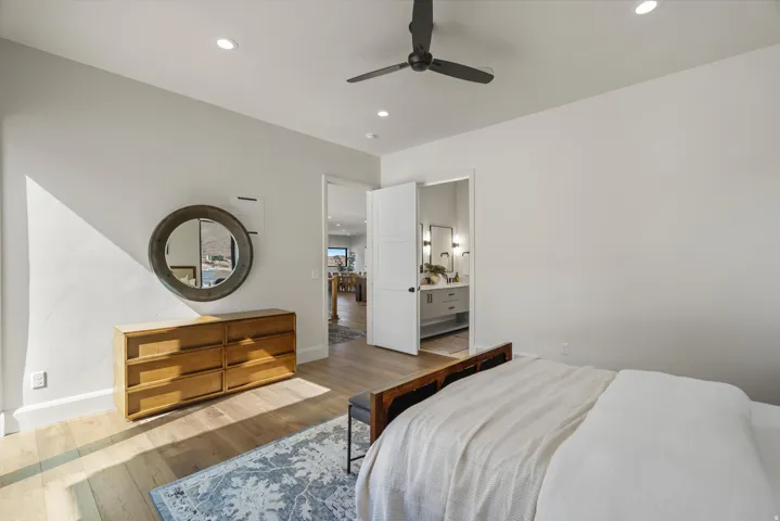 Bedroom featuring wood-type flooring, recessed lighting, ceiling fan, and ensuite bath