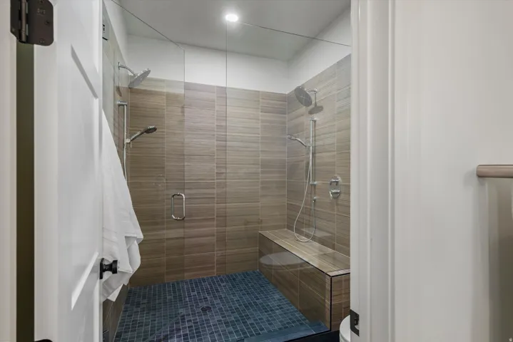 Full bath featuring a stall shower and toilet