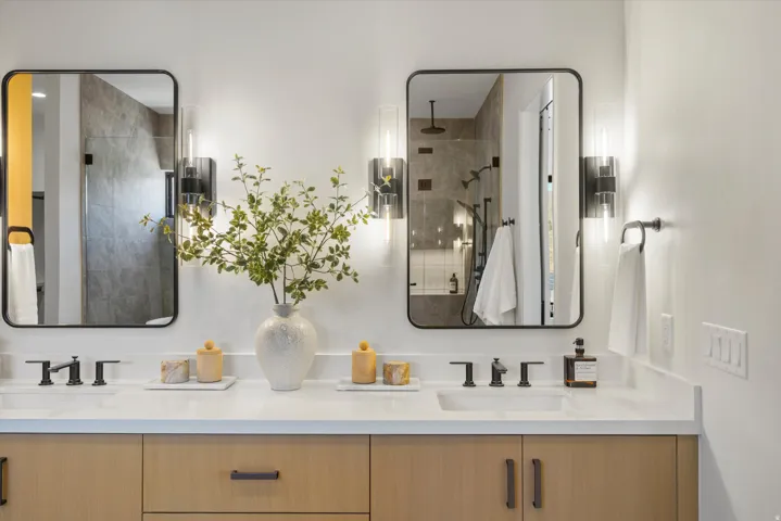Full bath featuring double vanity and a tile shower