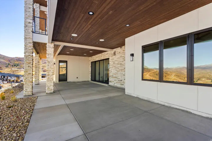 View of exterior entry featuring a mountain view, a patio area, and brick siding