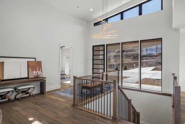 Staircase featuring wood-type flooring, a high ceiling, and a chandelier