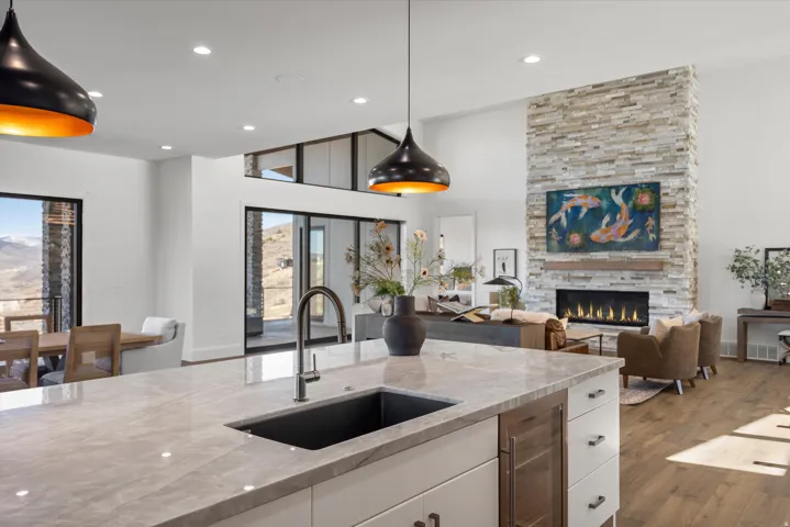 Kitchen with dark wood-type flooring, white cabinets, light stone counters, beverage cooler, and a high ceiling