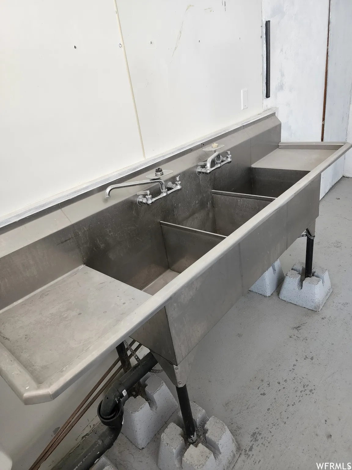 Detailed view of unfinished concrete flooring and a sink
