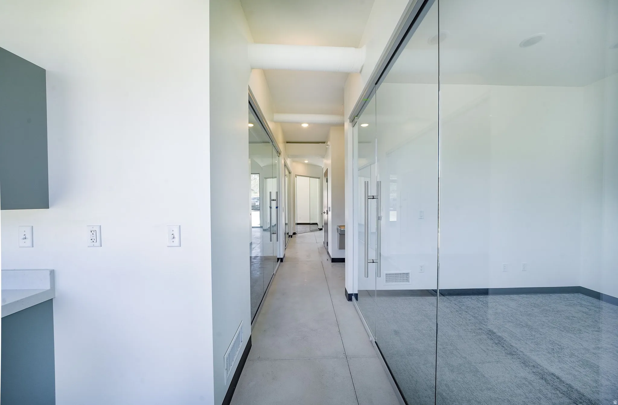 Hall featuring concrete flooring and recessed lighting