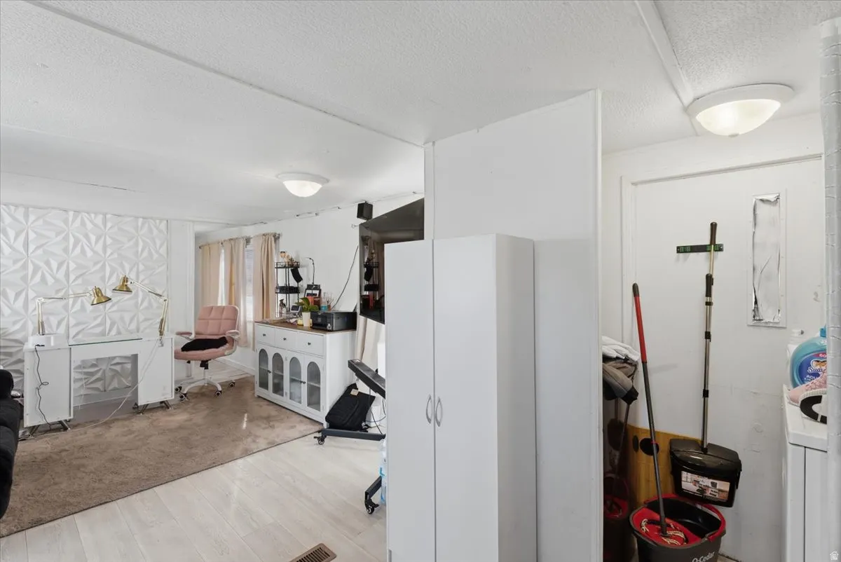 Misc room featuring a textured ceiling and light wood-type flooring