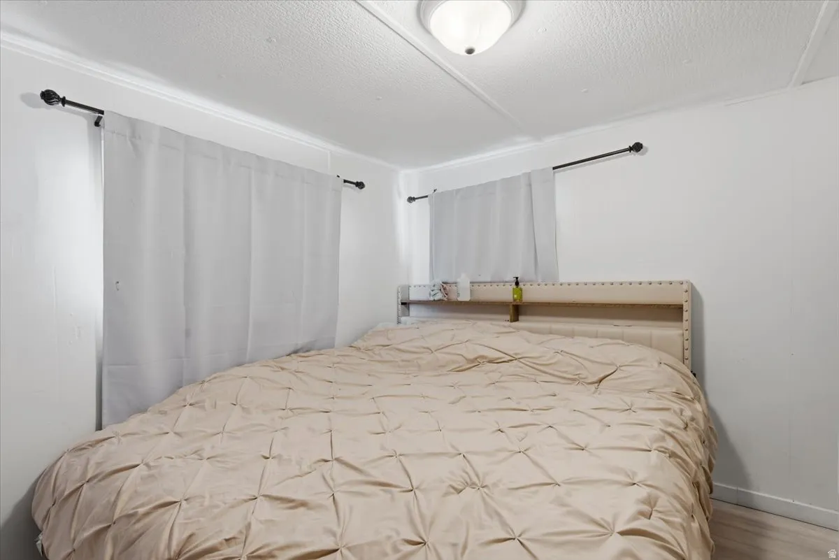 Bedroom featuring a textured ceiling and wood finished floors