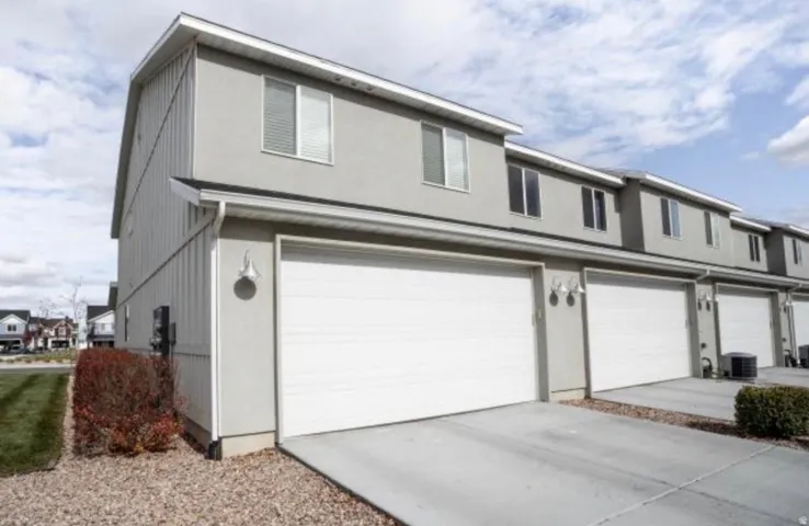 View of back of home with driveway and a garage