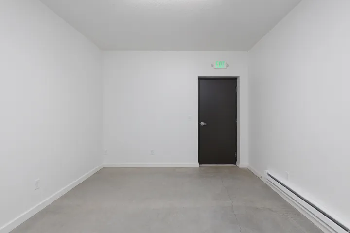 Spare room with a baseboard heating unit and finished concrete floors