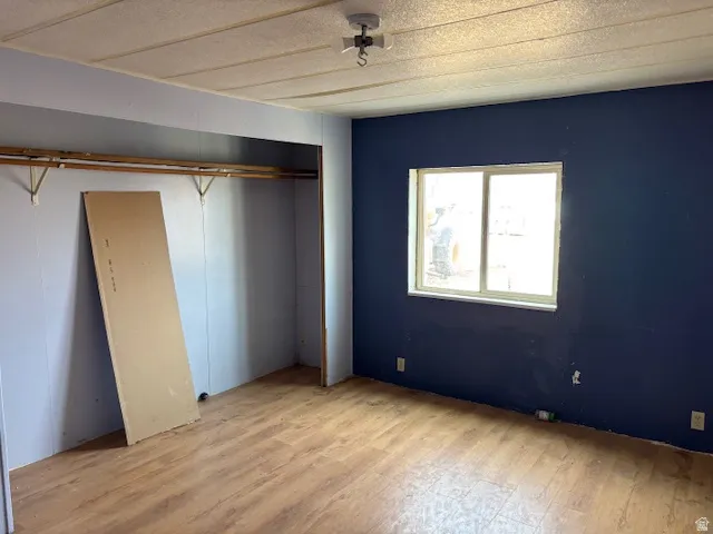 Unfurnished bedroom featuring light wood-style floors and a closet