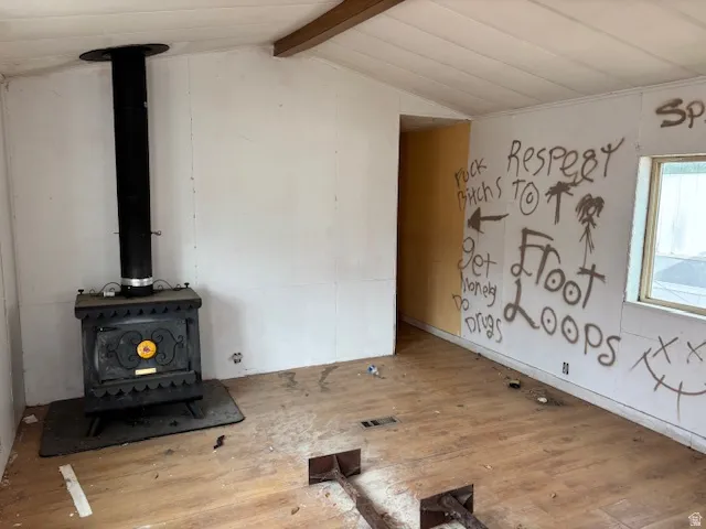 Unfurnished living room with a wood stove and hardwood / wood-style floors