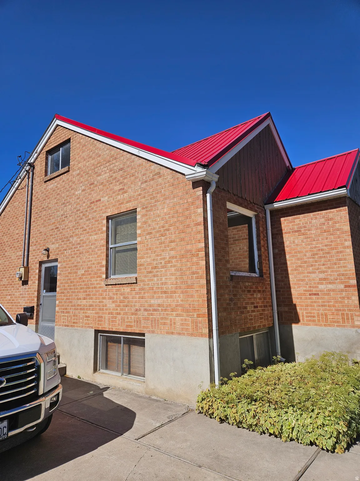 View of home's exterior with a metal roof and brick siding