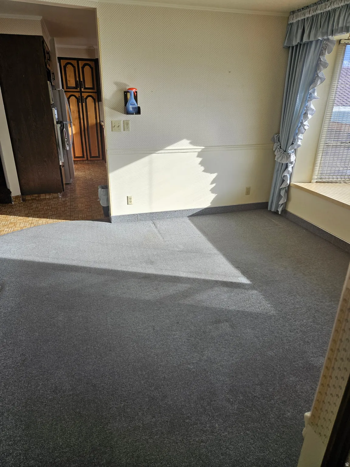 Empty room featuring dark colored carpet and baseboards