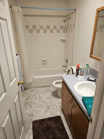 Bathroom with shower / bath combo with shower curtain and vanity