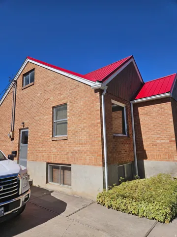 View of home's exterior with a metal roof and brick siding