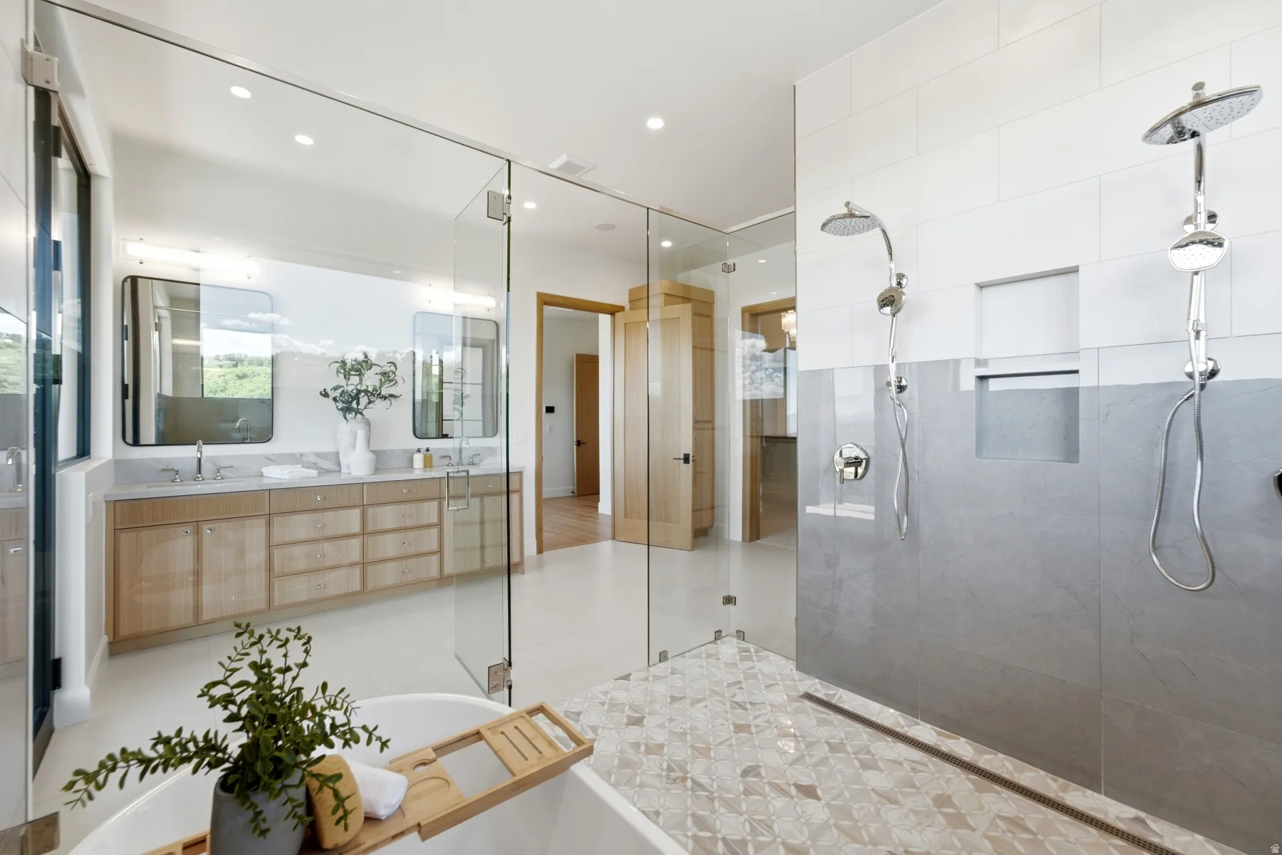 Glass-enclosed shower with dual shower heads and a patterned tile floor