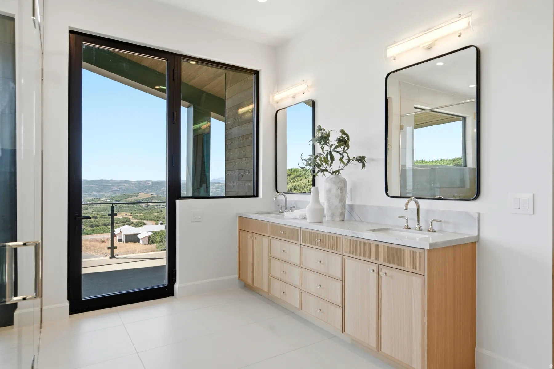 Double vanity with natural wood-finish cabinetry, integrated sinks, and polished chrome fixtures