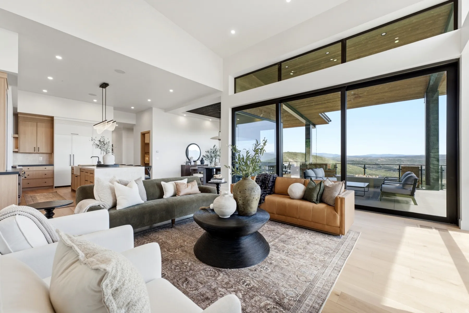 Open-concept living space featuring large sliding glass doors, transom windows, light wood-finish flooring, and recessed lighting