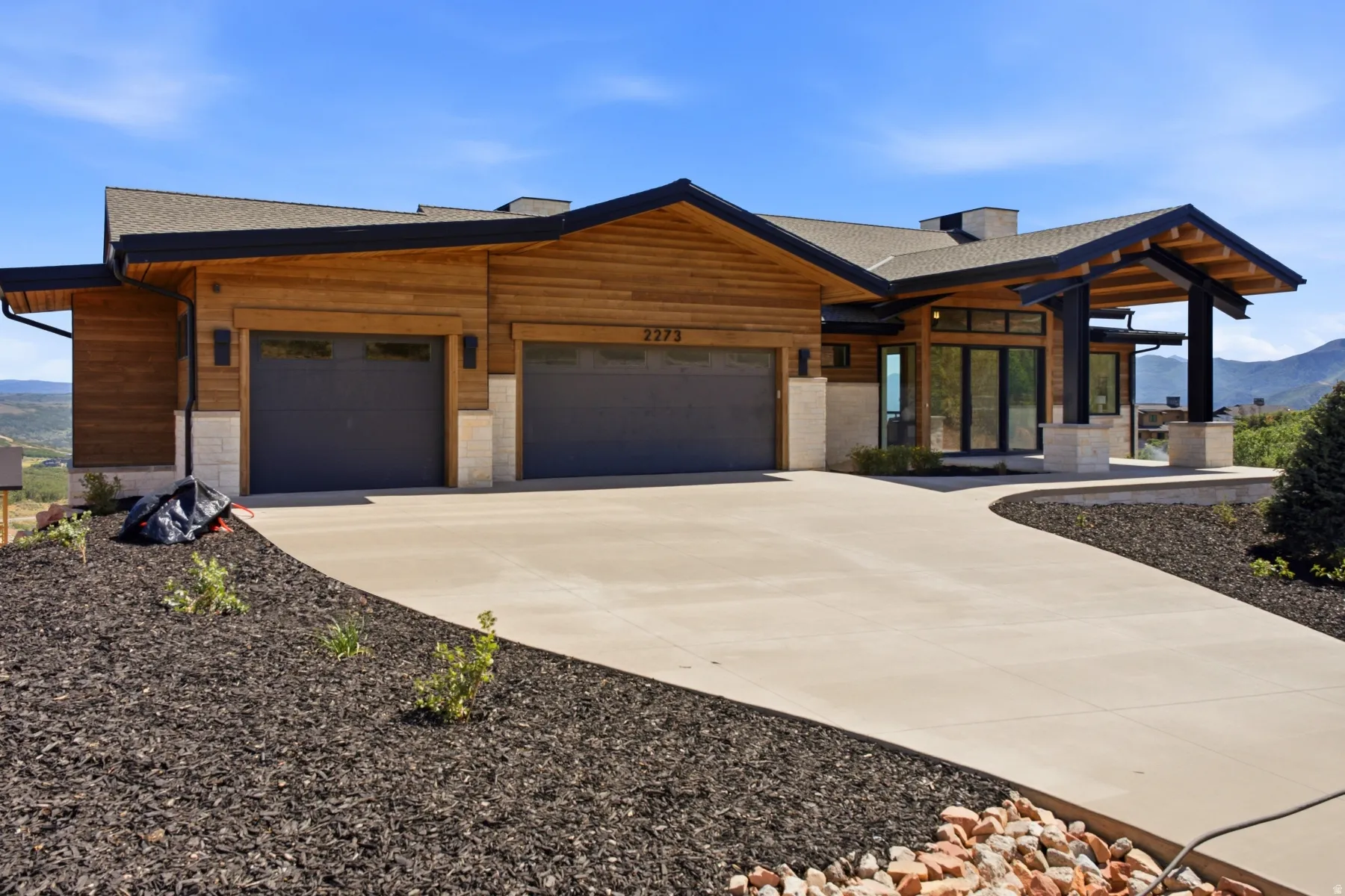 Contemporary single-story residence featuring natural wood siding and stone accents