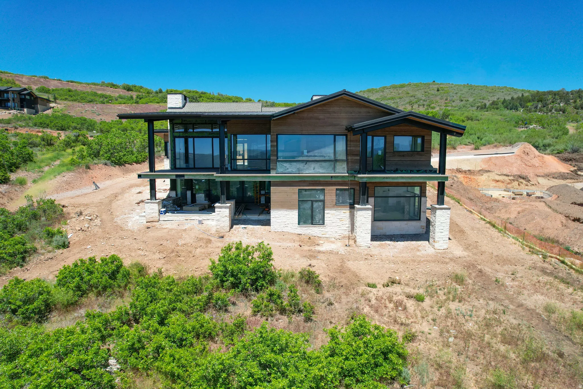 Hillside residence featuring a multi-level design with extensive glazing