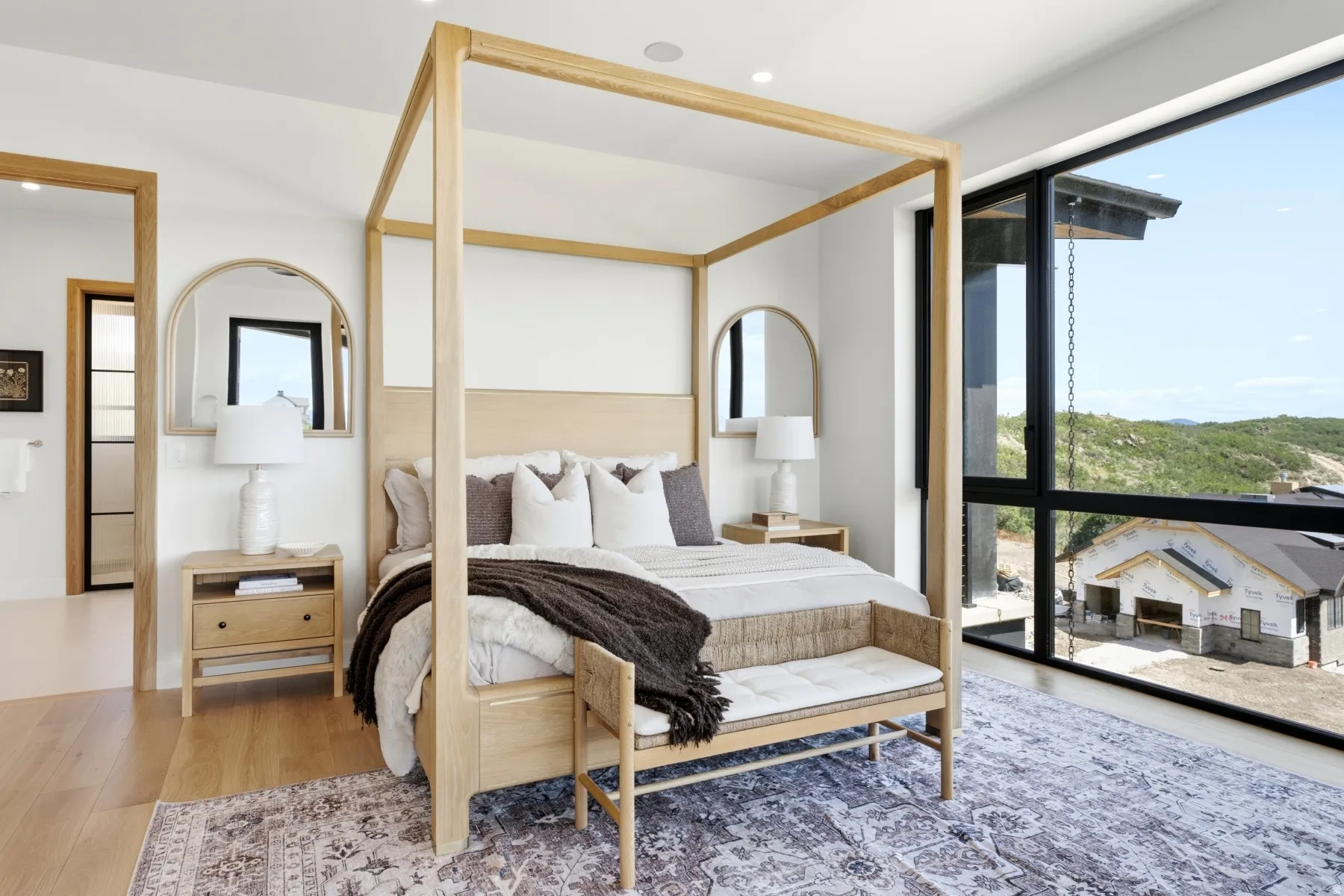 Spacious interior featuring wood-finish flooring, white walls, and an expansive window with black framing