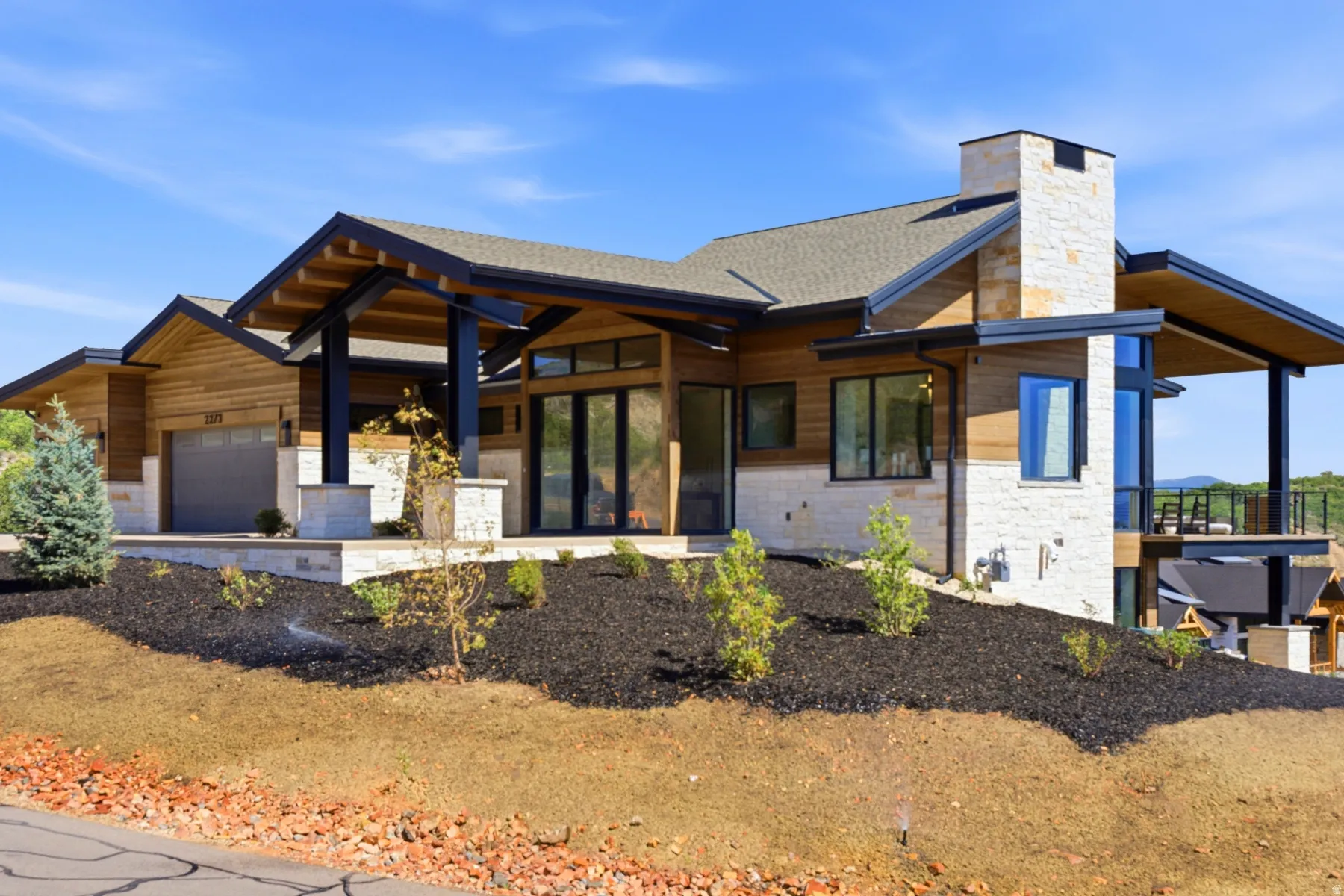 Contemporary single-family residence featuring wood siding and stone accents