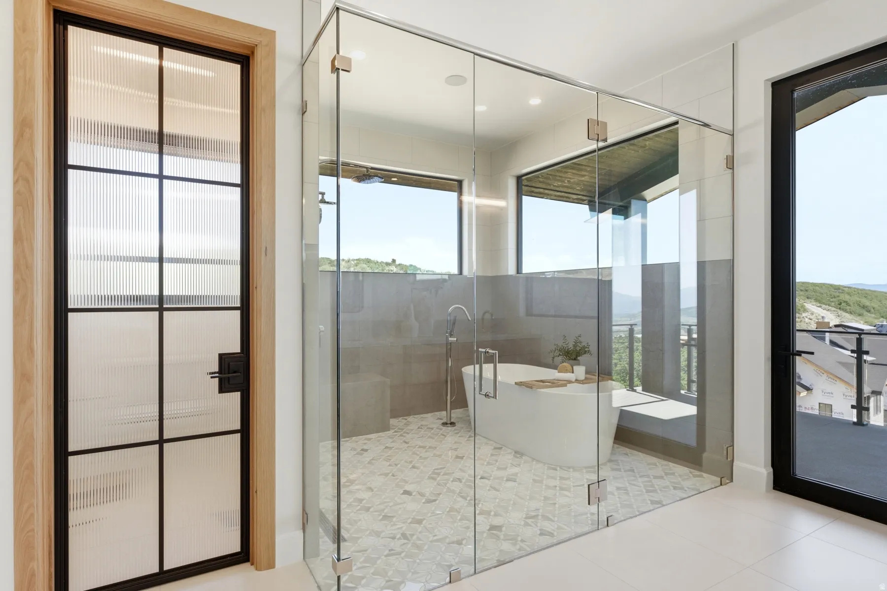 Enclosed glass shower and freestanding tub with tile flooring